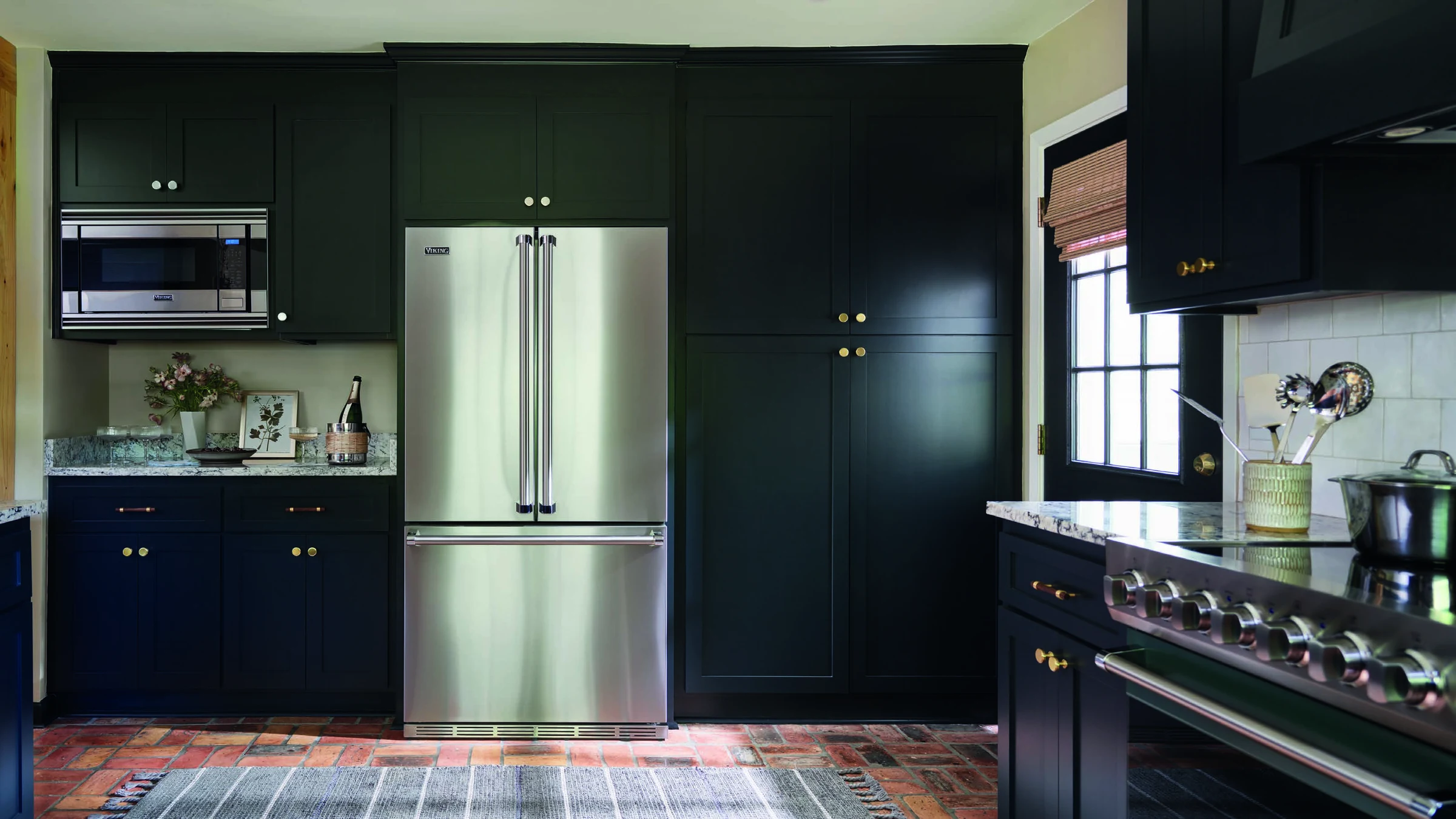 Cozinha com refrigerador French Door e fogão Viking em marcenaria preta